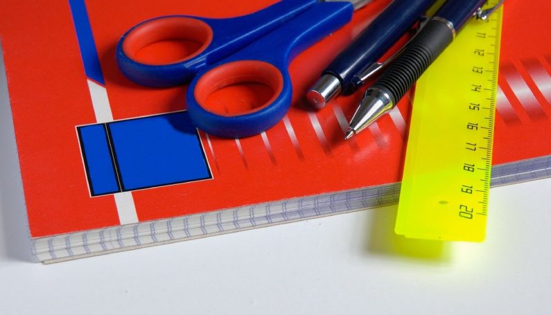 back-to-school supplies, including scissors, pens, ruler, and notebook