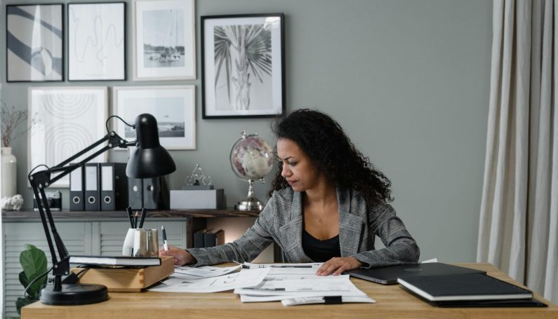 woman working at desk (motherhood and career ambition)