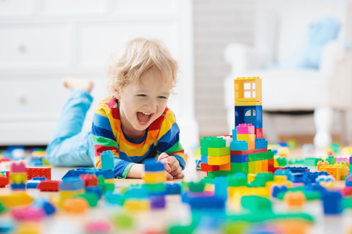 happy child playing with blocks (why i play with my children as little as possible)