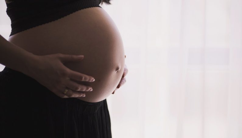 pregnant woman holding bare belly