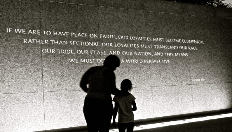 adult and child standing in front of Martin Luther King Jr. quote