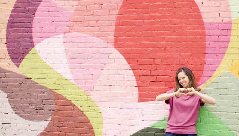 Woman in front of colorful mural