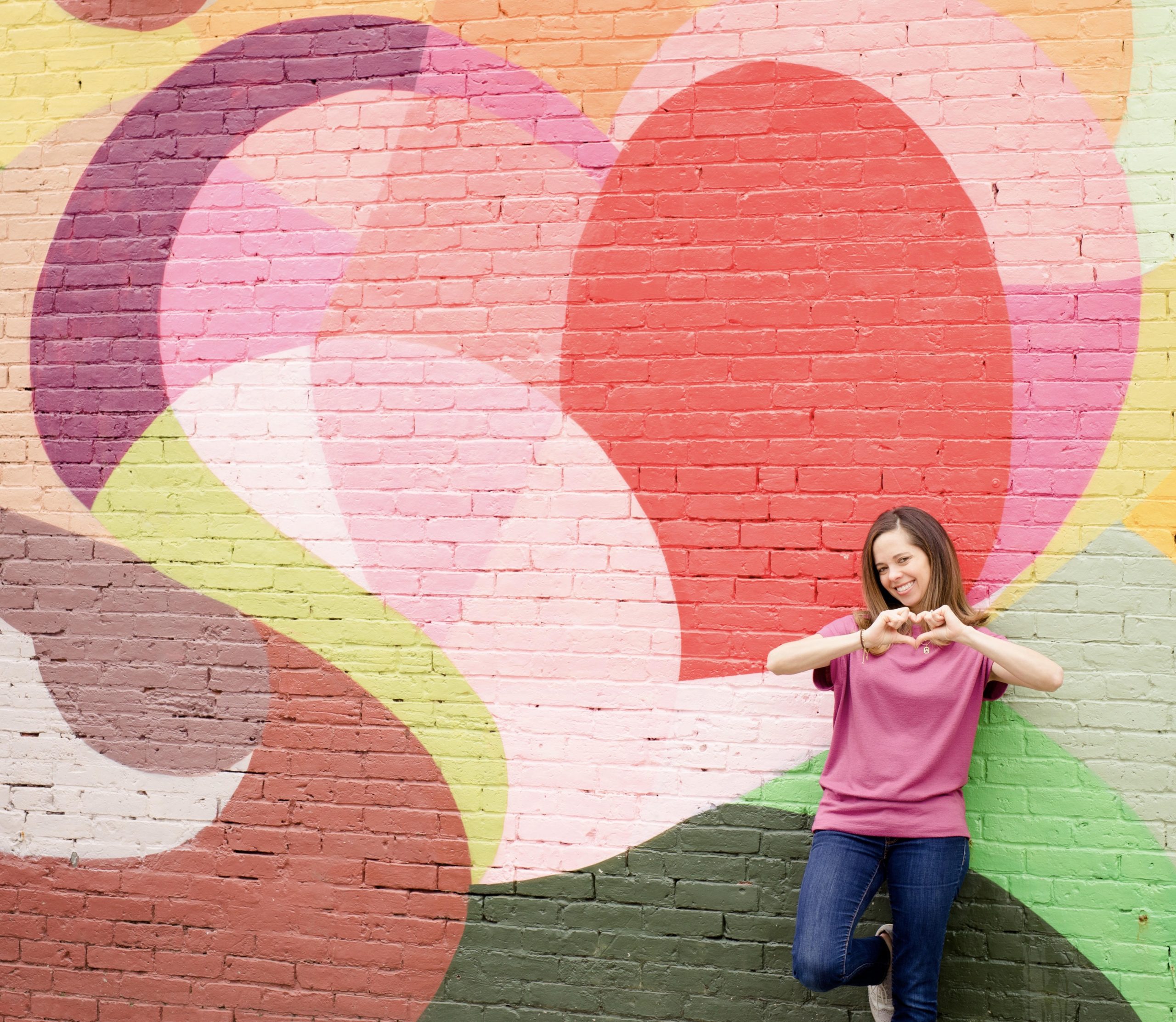 Woman in front of colorful mural