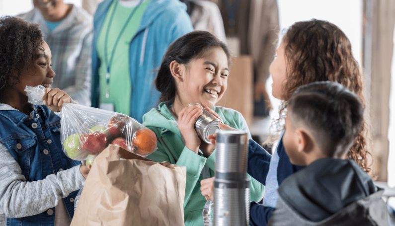 children volunteering at a food bank (where to volunteer with kids in Boston)